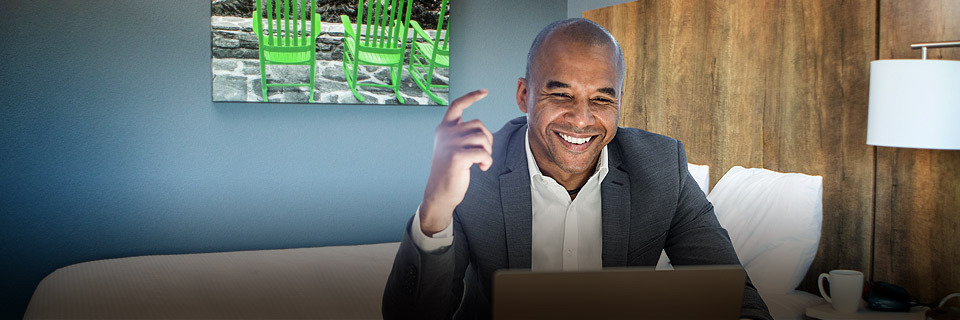 man working on laptop in hotel room