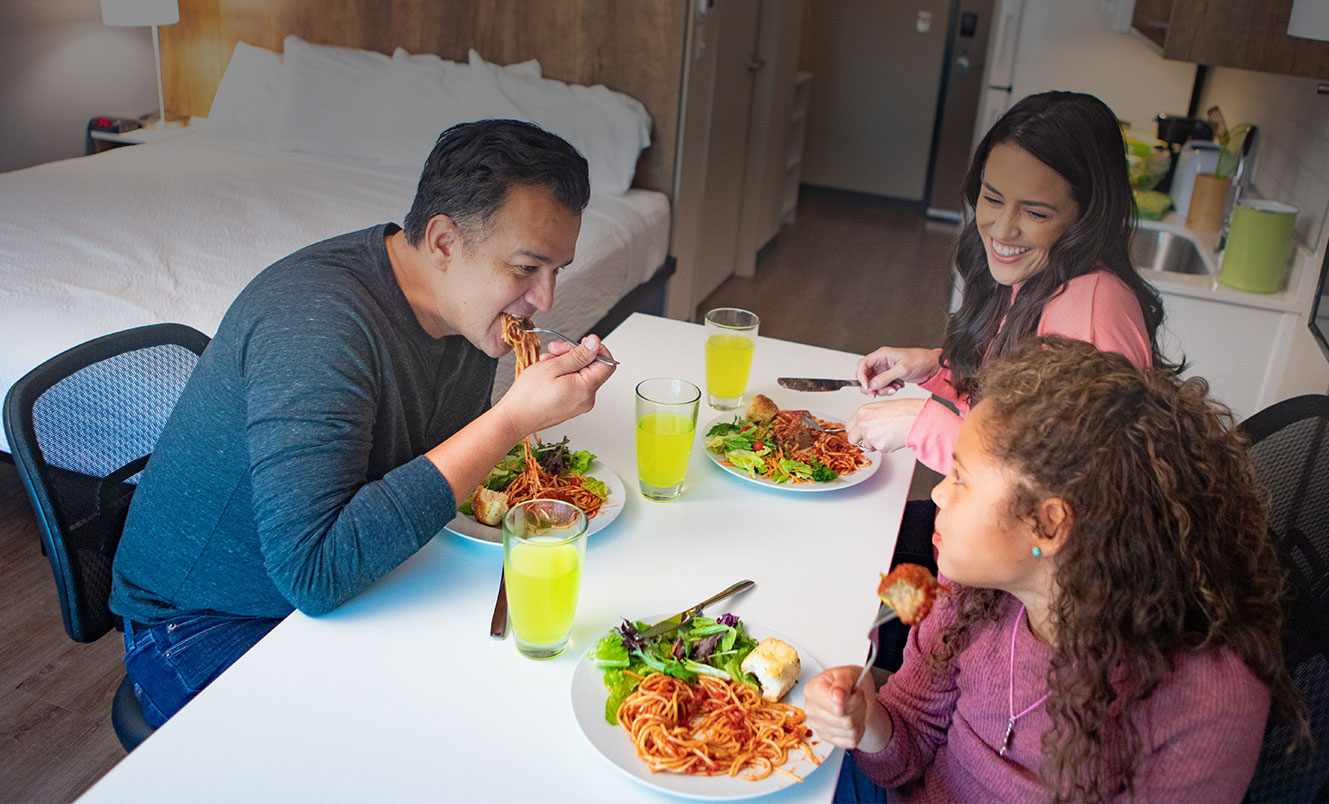 family in hotel room with kitchen