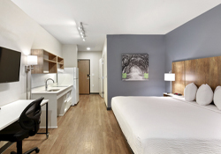 hotel room with workspace, kitchen, king bed